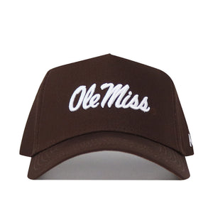 The Ole Miss Americano Hat is a brown, high-quality cotton baseball cap with "Ole Miss" embroidered in white script on the front.