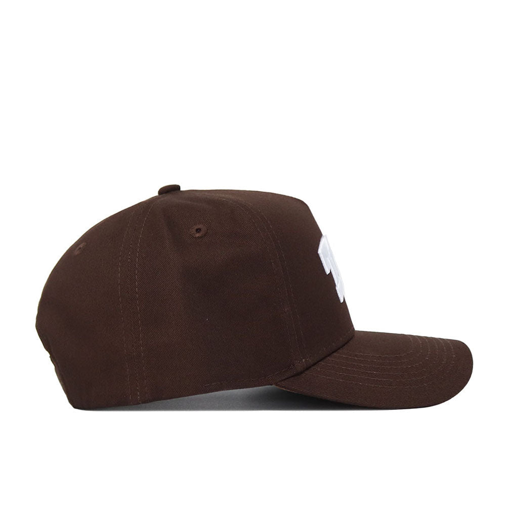 The TCU Americano Hat is a brown, structured-fit snapback cap with a curved brim and subtle white design on the front panel. Made from high-quality cotton, it stands out against a plain white background when viewed from the side.