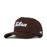 The Tulsa Americano Hat is a brown, high-quality cotton baseball cap with "Tulsa" in white script on the front and "NR" embroidered in white on the side, featuring a structured fit design.
