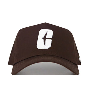 The UNC Charlotte Americano Hat is a brown snapback featuring a bold white "C" with a vertical cutout on the front, crafted from high-quality cotton. Shown on a plain white background.