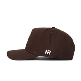 The Texas Tech Americano Hat is a brown baseball cap seen from the side, with white “NR” stitched on the panel. Made of high-quality cotton, it features a curved brim, a plain crown, and an adjustable snapback closure for comfort.