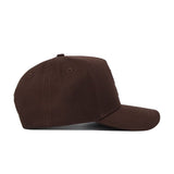 The Texas Tech Americano Hat is shown in a side view on a plain white background. This brown baseball cap features a curved brim and is crafted from high-quality, solid cotton fabric without any adornments.