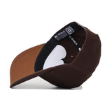 The Western Carolina Americano Hat, a brown snapback shown upside down, reveals its black inner lining, white adjustment band with a QR code, and an inside label reading NO RIVALS, emphasizing its structured fit.