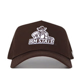 The New Mexico State Americano Hat is a brown snapback baseball cap featuring the NM State logo with a white outline of a cowboy holding pistols and "NM STATE" beneath. Made from high-quality cotton and officially licensed for fans.