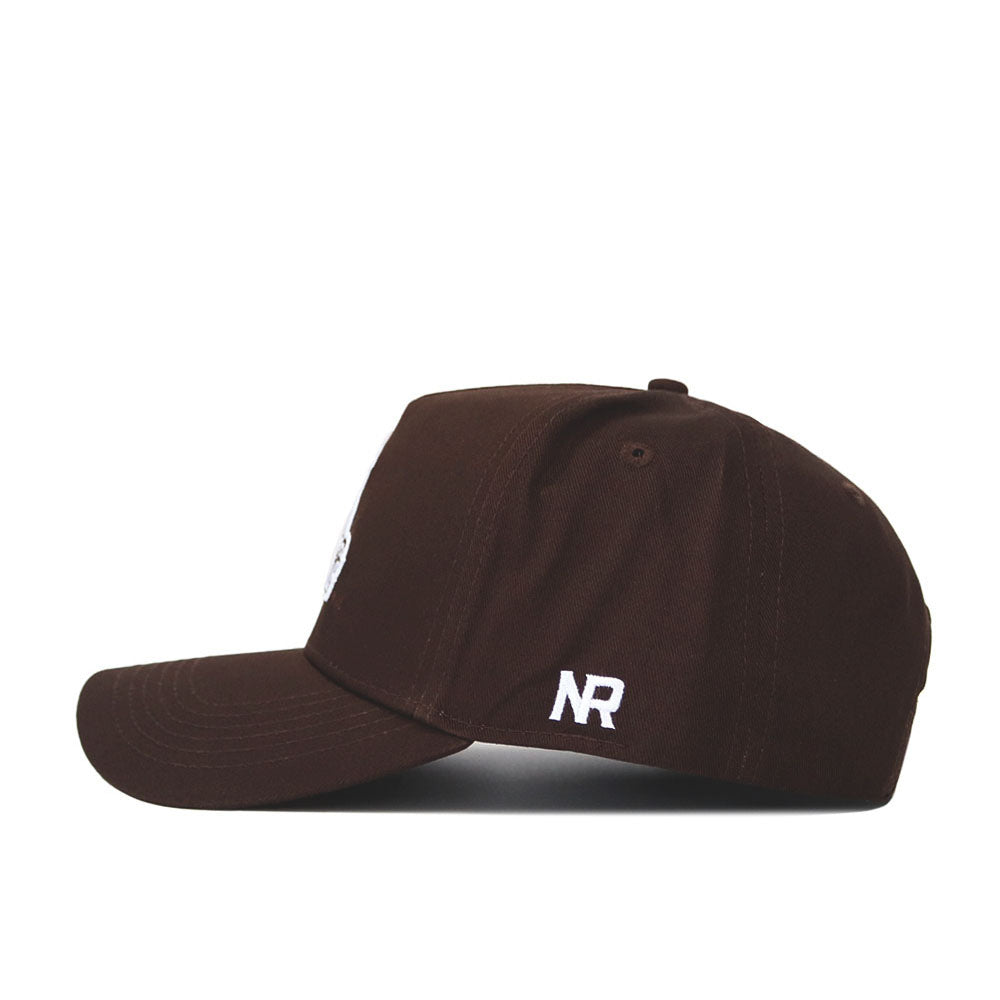 The New Mexico State Americano Hat is a dark brown snapback baseball cap with a flat bill, side view. Made from high-quality cotton, it features white embroidered NR letters on the back panel.