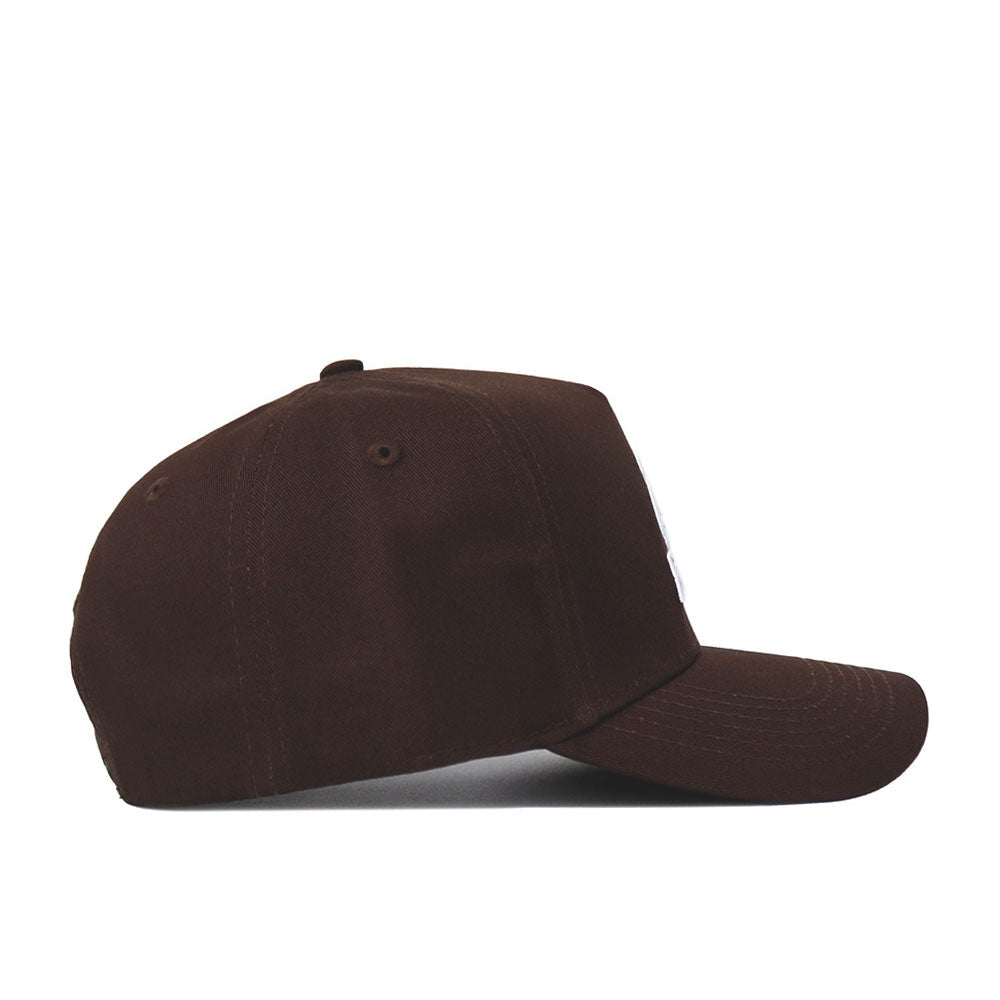 The New Mexico State Americano Hat is a dark brown baseball cap made of high-quality cotton, shown from the side with a curved brim and visible stitching against a plain white background.
