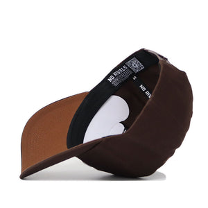 The New Mexico State Americano Hat is a brown snapback baseball cap made from high quality cotton, shown angled with the brim left. It features a black inner band with NO RIVALS text and a QR code.