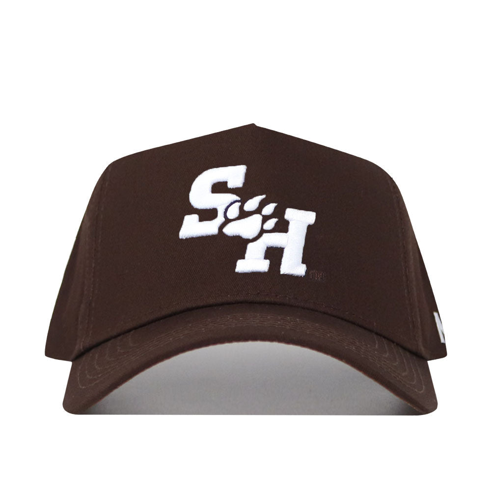 The Sam Houston State Americano Hat is a brown high-quality cotton baseball cap with white embroidered "S" and "H" letters separated by a paw print on the front. Its snapback design delivers comfort and style.