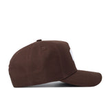 The Kansas State Americano Hat is a brown cotton baseball cap with white stitching on the brim and crown, a curved brim, and a front panel featuring a partially visible emblem or logo.