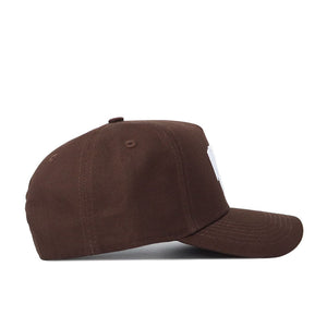 The Kansas State Americano Hat is a brown cotton baseball cap with white stitching on the brim and crown, a curved brim, and a front panel featuring a partially visible emblem or logo.