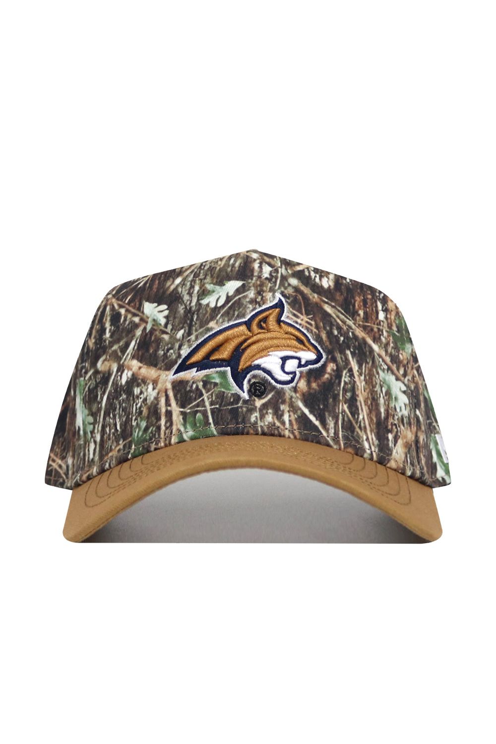 The Montana State Camo Hat - Explorer Edition features a camo design with a tan brim, an embroidered wildcat head logo outlined in white on the front, and is made from high-quality cotton for a structured fit.