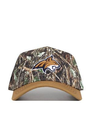 The Montana State Camo Hat - Explorer Edition features a camo design with a tan brim, an embroidered wildcat head logo outlined in white on the front, and is made from high-quality cotton for a structured fit.