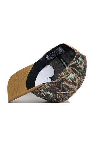 The Montana State Camo Hat - Explorer Edition is a structured snapback featuring a brown suede brim and camo-patterned crown. Made from high-quality cotton, the inside label displays NO RIVALS in white on a black band.