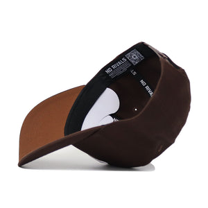 The SMU Americano Hat, a brown high-quality cotton baseball cap, is shown upside down with its black NO RIVALS inner band and part of the white underside visible. The bill faces forward and slightly left.