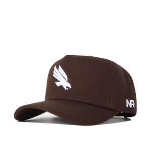 The North Texas Americano Hat is a brown cotton baseball cap with a white embroidered bird logo on the front, structured fit, and white NR initials on the left side.