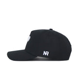 The Purdue Americano Hat is a black snapback, shown from the side, with white NR embroidery on the back and a small round patch on the front. Made from high-quality cotton, it offers a structured fit for lasting style.