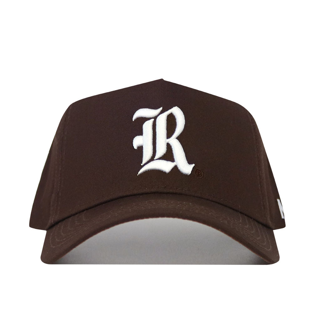The Rice Americano Hat is a brown baseball cap with a large white embroidered letter R on the front. This snapback features a structured fit, curved brim, and no other visible designs.