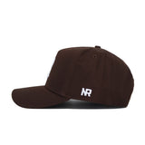 The Rice Americano Hat is a brown baseball cap with white embroidered "NR" near the back, featuring a curved brim, top button, and structured fit for comfort when viewed from the side.
