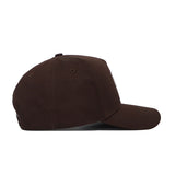 The Rice Americano Hat, a structured brown baseball cap, is displayed from the side on a flat surface with its bill facing right.