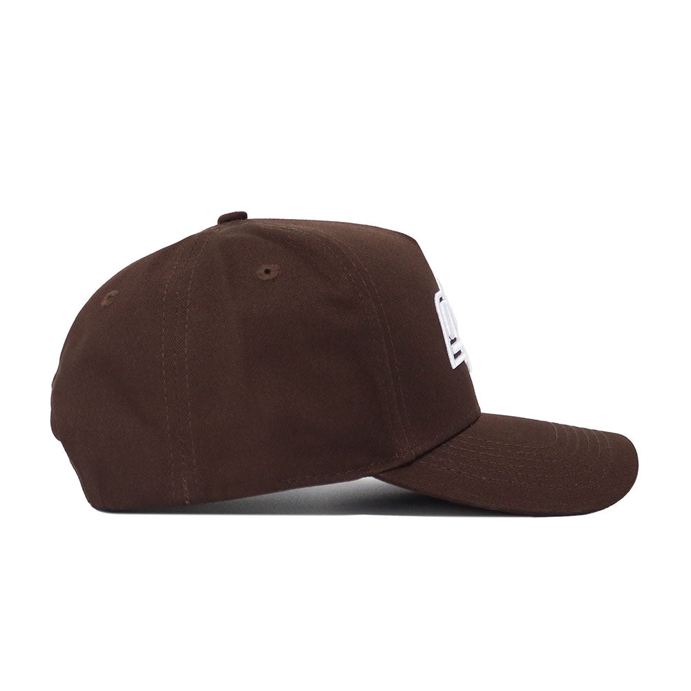 The Oklahoma State Americano Hat is a brown cotton baseball cap with a slightly curved brim, side view. It features two ventilation eyelets, a classic design, and partially visible white embroidery on the front.