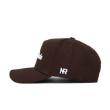 The Penn State Americano Hat is a brown cotton baseball cap shown from the side, with white embroidered "NR" on the side panel and partially visible white text on the front, offering comfort and durability.