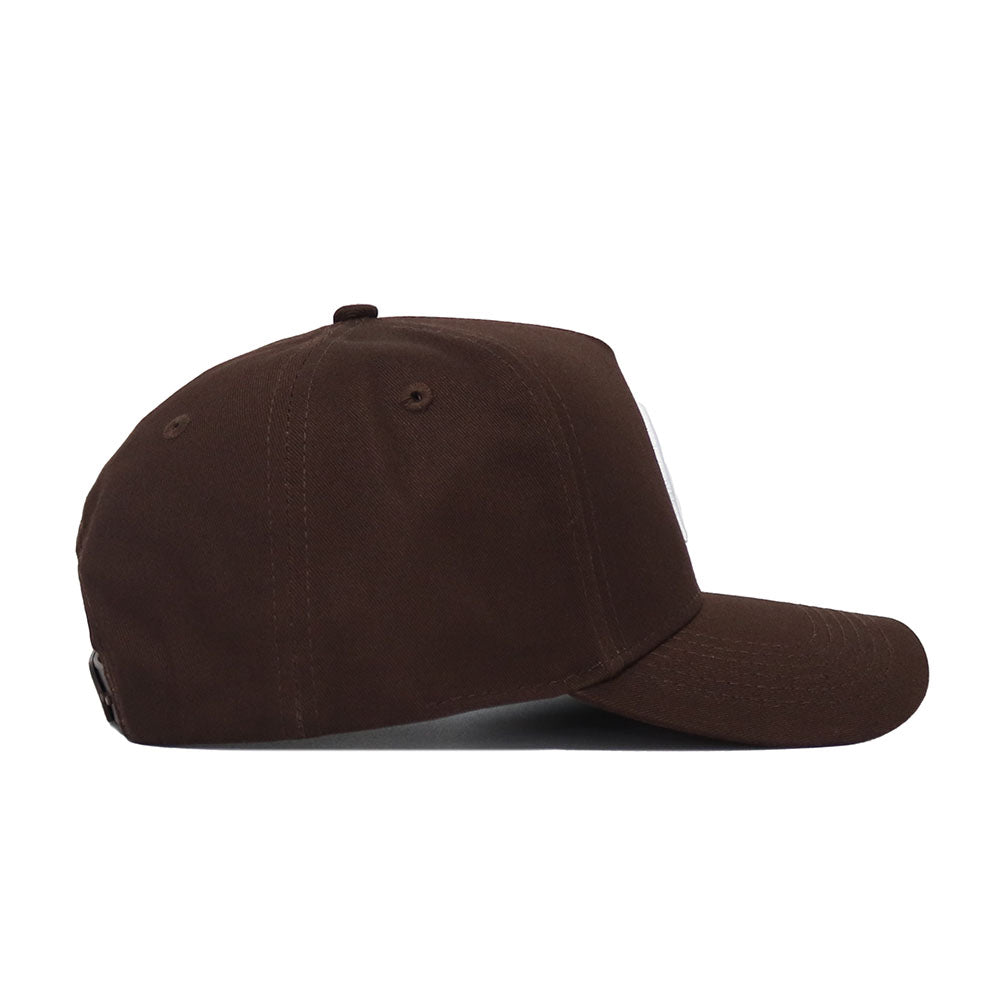 The Michigan State Americano Hat is a brown baseball cap shown from the side, featuring a curved brim, structured fit, and an adjustable snap back for personalized comfort.