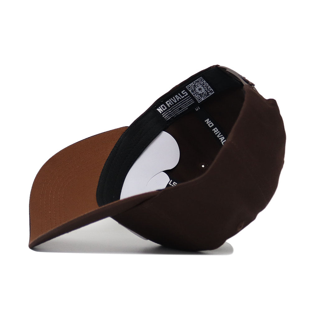 The Michigan State Americano Hat is a brown baseball cap, shown upside down to reveal the underside of the brim and an inner band labeled NO RIVALS in white. Made from high-quality cotton, it offers a structured fit for comfort.