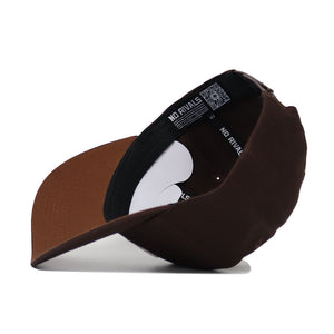 The Michigan State Americano Hat is a brown baseball cap, shown upside down to reveal the underside of the brim and an inner band labeled NO RIVALS in white. Made from high-quality cotton, it offers a structured fit for comfort.