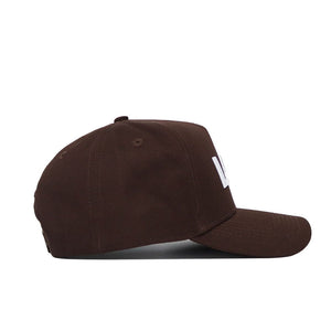 The LSU Americano Hat, a dark brown baseball cap with a structured fit, is shown from the side on a white background. It features cotton fabric, a curved brim, and raised white embroidery on the front panel.