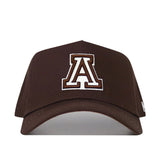 The University of Arizona Americano Hat is a brown cotton baseball cap with a large white and brown outlined "A" embroidered on the front, displayed against a plain white background.