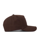 The University of Arizona Americano Hat is a brown cotton baseball cap shown from the side on a white background, featuring a curved brim, structured crown, and embroidered eyelets on top.