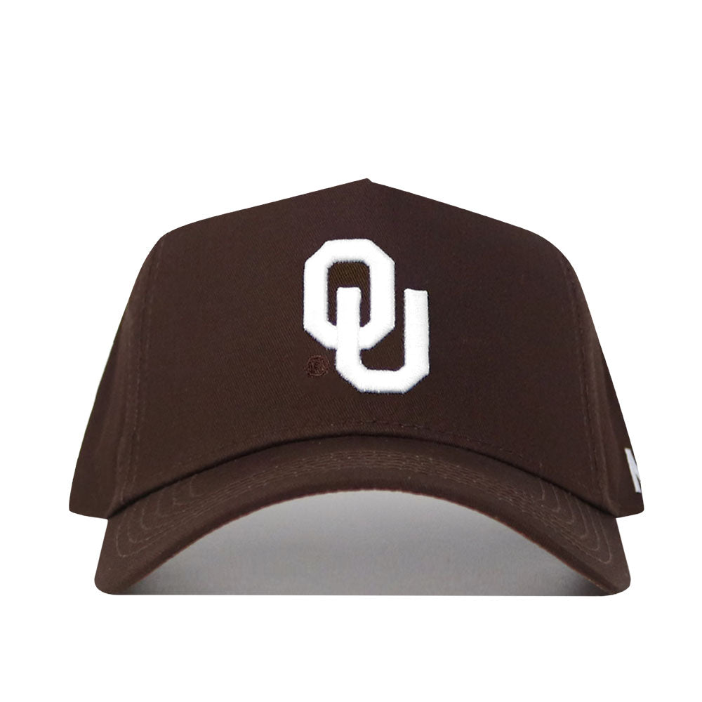 The Oklahoma Americano Hat is a brown snapback with a prominent white interlocking OU logo on the front, crafted from high-quality cotton and shown against a white background.