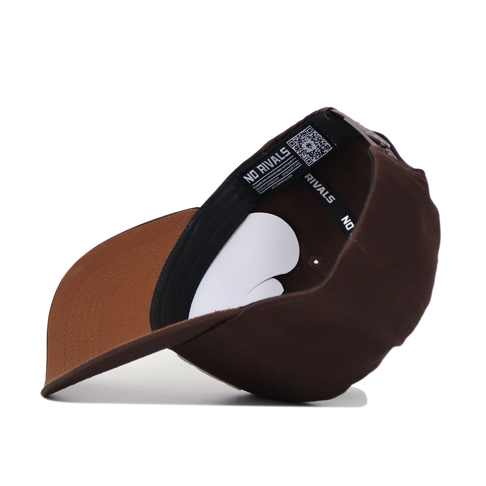 The ECU (East Carolina) Americano Hat is pictured upside down, showing its black inner band with NO RIVALS text and a QR code. This brown, high-quality cotton cap features a fitted design and a curved brim.