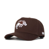 The NDSU Americano Hat is a brown cotton baseball cap with a white embroidered buffalo and disc on the front, plus white "NR" letters stitched on the left side.
