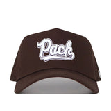 The Nevada Americano Hat is a brown snapback made from high-quality cotton, featuring "Pack" embroidered in white stylized script on the front.