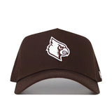 The Louisville Americano Hat is a brown snapback made from high quality cotton, featuring an embroidered white bird head logo with a fierce expression on the front.