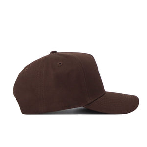 The Louisville Americano Hat is a plain brown snapback made from high-quality cotton, featuring a curved brim and top button, displayed from the side against a white background.