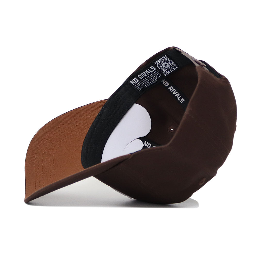 The Houston Americano Hat is a brown snapback shown from the underside, featuring a black inner band with "NO RIVALS" in white, a white tag with a QR code, and a structured fit for comfort.