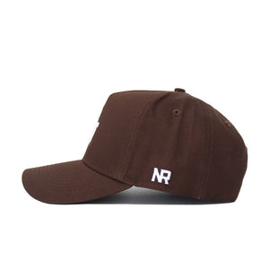 The Baylor Americano Hat is a brown structured baseball cap, shown from the side, with white "NR" embroidery near the back above its adjustable strap.