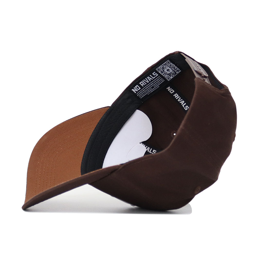The Baylor Americano Hat, shown from the side with its brim on a white surface, is a brown snapback made from high-quality cotton. It has a structured fit, an inside label reading "NO RIVALS," and a QR code on the interior band.