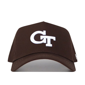 The Georgia Tech Americano Hat is a brown, high-quality cotton baseball cap with a white embroidered GT logo on the front. This structured snapback is displayed from the front against a white background.