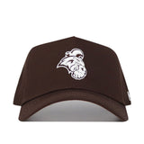 The Coastal Carolina Americano Hat is a brown, structured-fit cotton cap with a white embroidered bulldog mascot on the front, showcasing its bold logo and curved brim.
