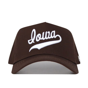 The Iowa Americano Hat is a brown snapback cap with "Iowa" embroidered in white script on the front, made from high-quality cotton. Its structured fit provides comfort and classic style for everyday wear.