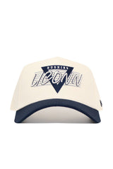 The UConn Triangle Game Cap Hat is a structured white cotton baseball cap with a navy brim, featuring a triangular "HUSKIES" patch above large embroidered "UCONN" text on the front.