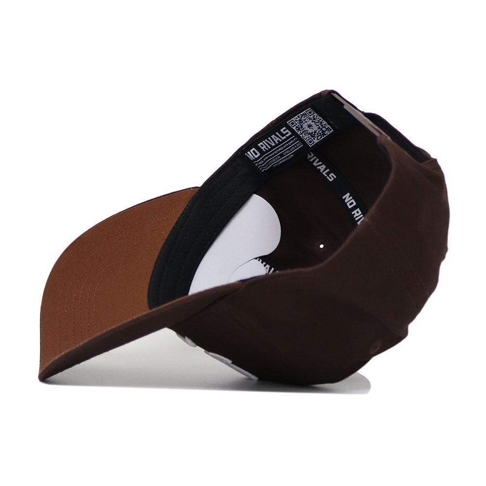 The Iowa Americano Hat is a brown and black snapback, shown upside down to reveal its black trim reading "NO RIVALS" and a small QR code on the label. Made from high-quality cotton for a structured fit.