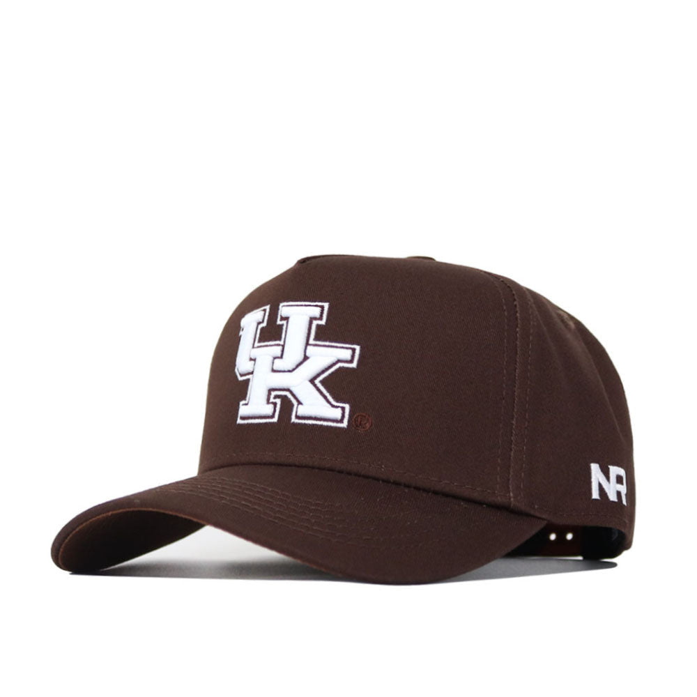 The Kentucky Americano Hat is a brown snapback featuring a bold white UK logo on the front and NR initials on the side. Made from high-quality cotton for a structured fit, it's shown angled against a white background.