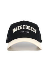 The No Rivals WAKE FOREST Established Hat is a black cap with a white brim, featuring "WAKE FOREST EST 1834" embroidered in white. Officially licensed, it’s made from high quality cotton and has an adjustable snap back for the perfect fit.