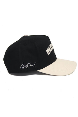 The No Rivals WAKE FOREST Established Hat is a black and white cotton baseball cap with white embroidered text on the front and side, a white brim, a top button, and an adjustable snap back for a custom fit.