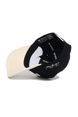 A black and white WAKE FOREST Established Hat by No Rivals is shown upside down, revealing inside labels. Made from high-quality cotton, it features a white signature on the black section of the cap.