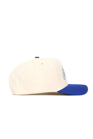The No Rivals Creighton Triangle Game Cap Hat is shown in a side view, featuring a structured fit with a white crown and blue brim, set against a plain white background.